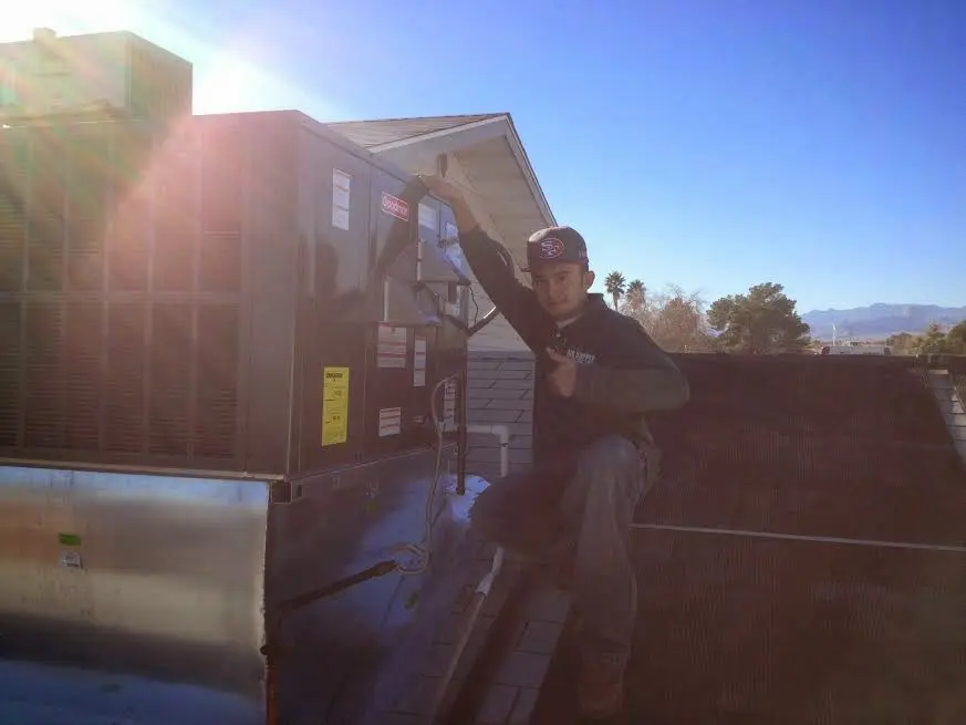HVAC technician performing AC Tune-Up on a rooftop unit in Buckhall